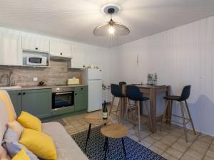 a living room with a couch and a kitchen with a table at Apartment Les Manoirs de la Côte by Interhome in Varaville