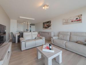 uma sala de estar com um sofá e uma mesa em Apartment Beachhouse with parking by Interhome em Blankenberge