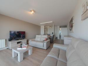 uma sala de estar com um sofá e uma televisão em Apartment Beachhouse with parking by Interhome em Blankenberge