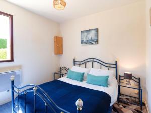 a bedroom with a blue and white bed with blue pillows at Apartment Les Maisons de la Mer by Interhome in Merville-Franceville-Plage