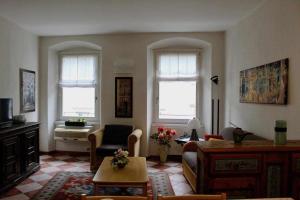 sala de estar con 2 ventanas y sofá en Appartamento La Contrada, en Trento