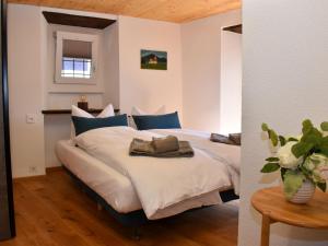 - une chambre avec un lit doté d'oreillers bleus et d'une table dans l'établissement Holiday Home Bertino by Interhome, à Cugnasco