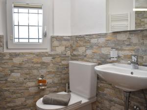 La salle de bains est pourvue de toilettes blanches et d'un lavabo. dans l'établissement Holiday Home Bertino by Interhome, à Cugnasco