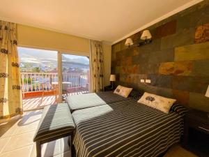 San Nicolás的住宿－Hotel La Aldea Suites，一间卧室设有一张床和一个大窗户