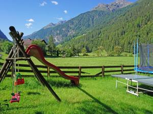 a slide in a field with a table and mountains at Apartment Top 1 by Interhome in Kaunertal