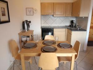 een keuken met een houten tafel met borden en glazen erop bij Apartment Grand Panorama A5 by Interhome in Nendaz