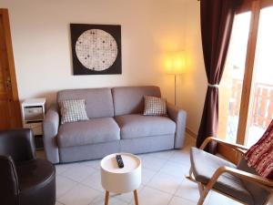 een woonkamer met een bank en 2 stoelen bij Apartment Grand Panorama A5 by Interhome in Nendaz