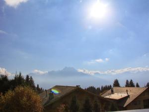 a sky with the sun and mountains in the background at Apartment Le Bouquetin 5 by Interhome in Villars-sur-Ollon