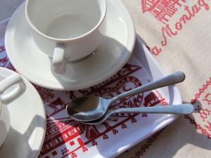 a cup of coffee and a spoon on a plate at Apartment Le Bouquetin 5 by Interhome in Villars-sur-Ollon