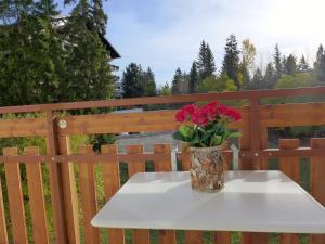 a vase of roses sitting on a table on a fence at Apartment Barzettes-Vacances B-11 by Interhome in Crans-Montana