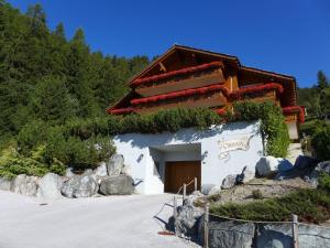 a building on a hill with rocks in front of it at Apartment Orana by Interhome in Crans-Montana