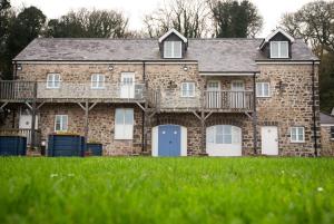 a large brick house with white doors and a balcony at Trefloyne Manor in Tenby