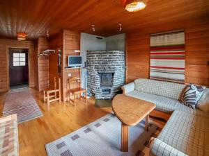 ein Wohnzimmer mit Couch und Kamin in der Unterkunft Holiday Home Mäkitupa 2 by Interhome in Kuusamo