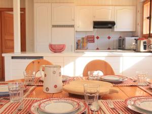 uma cozinha com uma mesa de madeira com pratos e copos em Apartment Rose des Vents 4 by Interhome em Villars-sur-Ollon