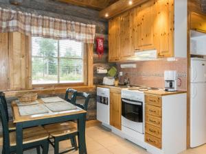 eine Küche mit einem Tisch, einem Herd und einer Spüle in der Unterkunft Holiday Home Lauri 2 by Interhome in Sirkka