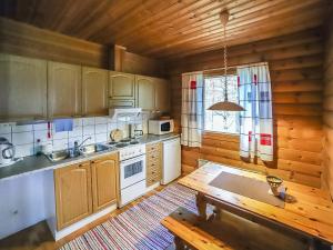 eine Küche mit Holzschränken und einem Holztisch in der Unterkunft Holiday Home Pihatupa 1 by Interhome in Kuusamo