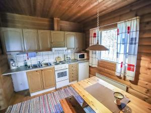 eine Küche mit Holzschränken und einem Tisch im Zimmer in der Unterkunft Holiday Home Pihatupa 1 by Interhome in Kuusamo