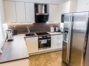 a kitchen with white cabinets and a stainless steel refrigerator at Holiday Home Levinkolmio c6 by Interhome in Sirkka