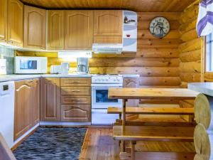 a kitchen with wooden cabinets and a wooden table at Holiday Home Lumomarja by Interhome in Pyhätunturi