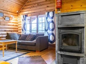 a living room with a couch and a fireplace at Holiday Home Lumomarja by Interhome in Pyhätunturi