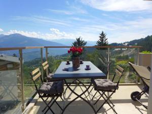 a table and chairs on a balcony with a view at Apartment Clair-Azur-3 by Interhome in Crans-Montana