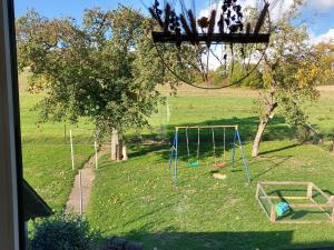 a playground in a field with a swing at Apartment Am Meintetal by Interhome in Lügde