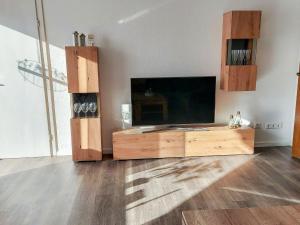 a living room with a tv and a wooden entertainment center at Apartment Am Meintetal by Interhome in Lügde