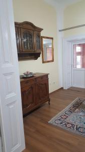 a room with a wooden dresser and a mirror at Apartman Dane in Kikinda