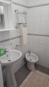 a white bathroom with a sink and a toilet at Apartman Dane in Kikinda