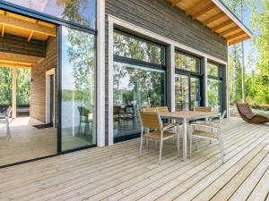 a wooden deck with a table and chairs on it at Holiday Home Hot pool cottage kesäranta by Interhome in Ihamaniemi