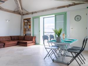 salon ze stołem, krzesłami i kanapą w obiekcie Apartment Les Araucarias by Interhome w Cannes