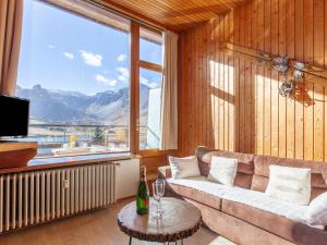 a living room with a couch and a large window at Apartment Le Grande Motte - Le Lac by Interhome in Tignes