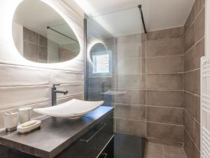 a bathroom with a sink and a mirror at Apartment Le Grande Motte - Le Lac by Interhome in Tignes
