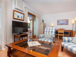 een woonkamer met een tv en een bank en een tafel bij Apartment Sa Riera Beach by Interhome in Begur
