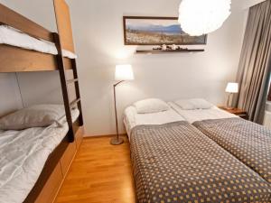 a bedroom with two bunk beds and a lamp at Holiday Home Ylläs chalets a104 by Interhome in Ylläsjärvi