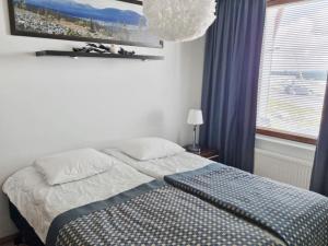 a bedroom with a bed and a window with blue curtains at Holiday Home Ylläs chalets a104 by Interhome in Ylläsjärvi