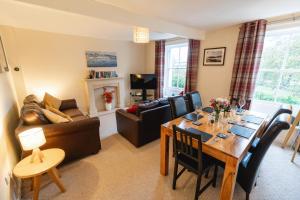 a living room with a table and a dining room at Church Cottage in Maryport
