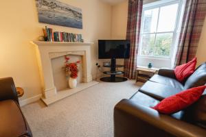 a living room with a couch and a fireplace at Church Cottage in Maryport