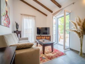 a living room with a couch and a tv and a table at Holiday Home Artatore by Interhome in Mali Lošinj