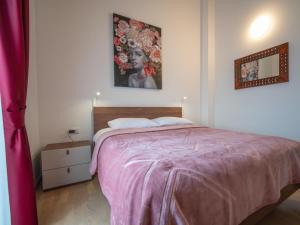 a bedroom with a bed with a pink blanket at Holiday Home Artatore by Interhome in Mali Lošinj