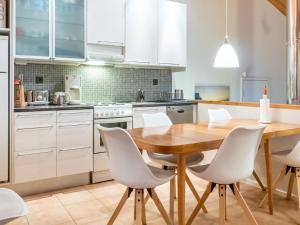 a kitchen with a wooden table and white chairs at Holiday Home Sallan lumous a by Interhome in Salla