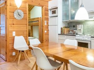 a kitchen and dining room with a wooden table and white chairs at Holiday Home Sallan lumous a by Interhome in Salla