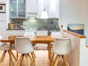 a kitchen with a wooden table and white chairs at Holiday Home Sallan lumous a by Interhome in Salla