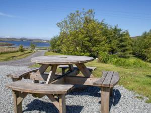a wooden picnic table and benches on the side of a road at Holiday Home Ploughman by Interhome in Eyre