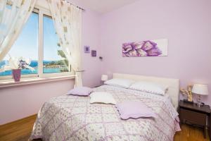 a white bedroom with a bed and a window at Apartments Suzy in Split