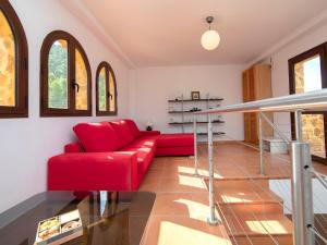 un sofá rojo en una sala de estar con ventanas en Villa Mucho by Interhome, en Finestrat