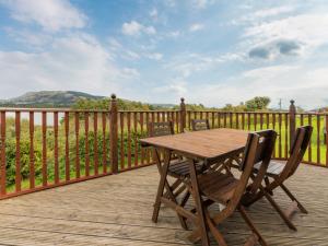 a wooden table and chairs on a wooden deck at Chalet Loch Side Lodge 5 by Interhome in Kinross
