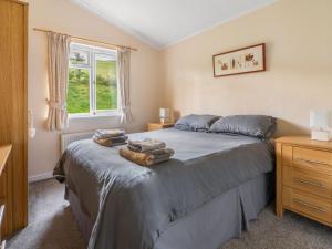 a bedroom with a bed with towels on it at Chalet Loch Side Lodge 5 by Interhome in Kinross