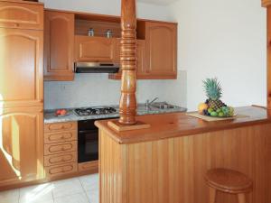 a kitchen with wooden cabinets and a bowl of fruit on the counter at Apartment Biletić - LBN374 by Interhome in Barban