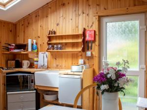 a kitchen with wooden walls and a white refrigerator at Chalet Skye Garden Accommodation by Interhome in Portree